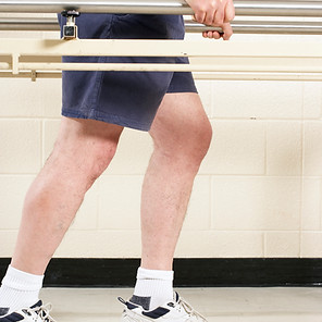 Man using bars to walk in a physio session