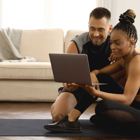 Couple in work out gear reviewing their love report card on a laptop