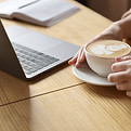 Cup of coffee beside a laptop representing comfort and connection in online counselling sessions