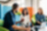 Colleagues talking happily while seated in colourful office chairs