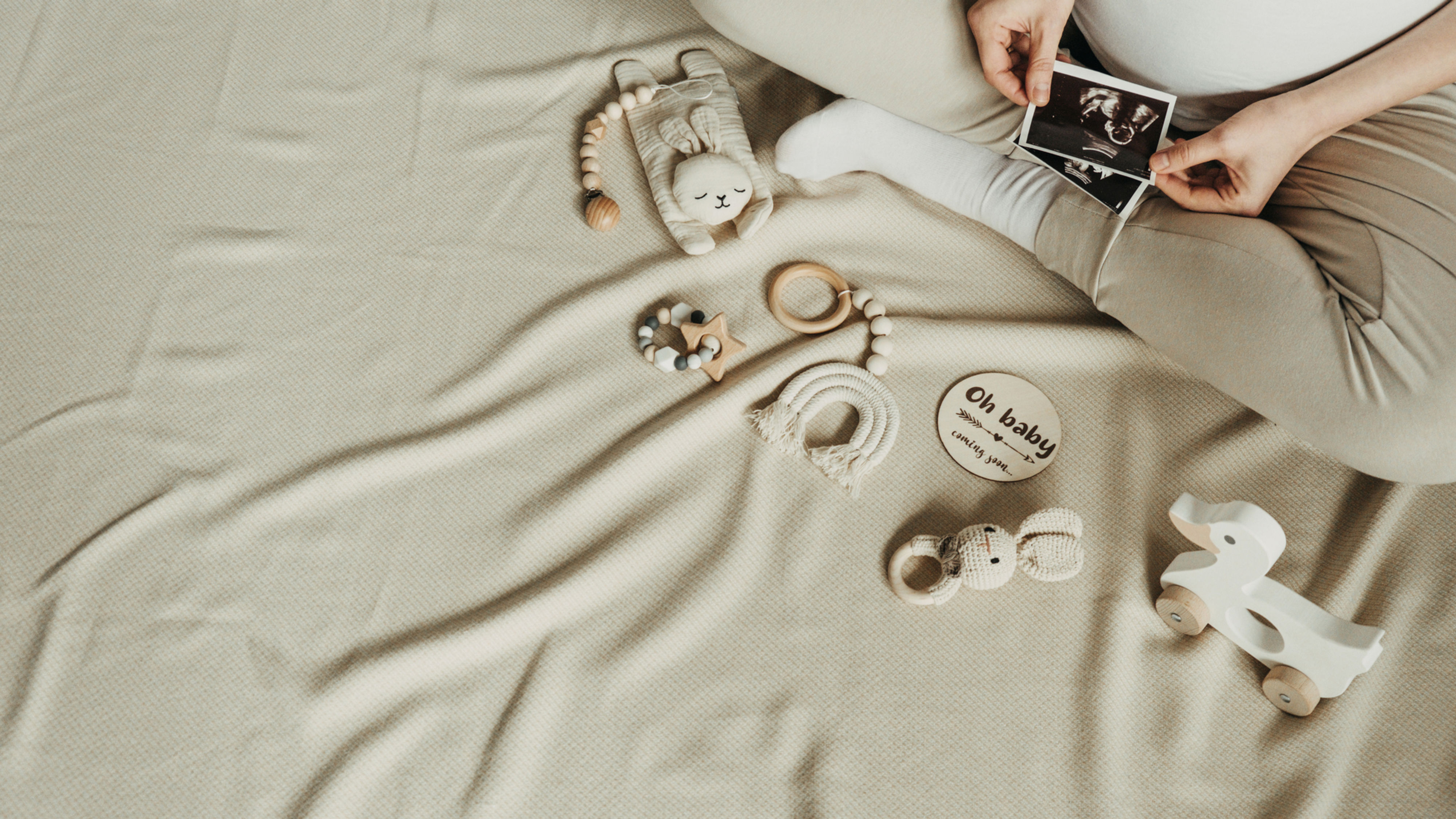 baby toys and pregnant mom holding ultrasound picture