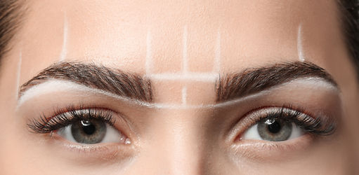 Gros plan sur un regard féminin où le dessin en blanc du placement des sourcils, a été effectué, afin de procéder à un maquillage permanent des sourcils