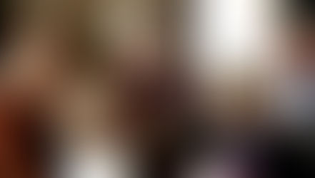 Three generations of a family looking at a book