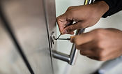 A residential locksmith lock picking a front door