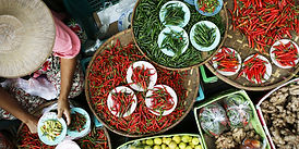 Asian woman selling various types of chillies
