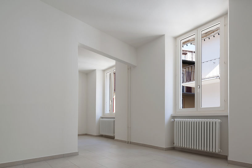Minimalist empty room in a renovated old house with white walls and bright natural lighting