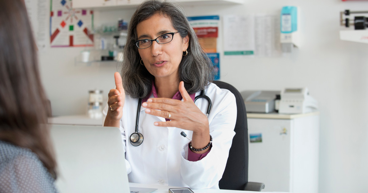 A person sitting with a healthcare professional in a warm, light-filled room, engaged in a supportive conversation.