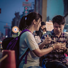 A man and woman eating street food
