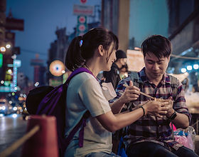 A man and woman eating street food