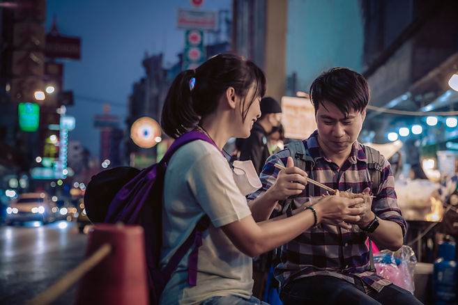 A man and woman eating street food