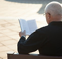 A Man Reading a Book Outdoors