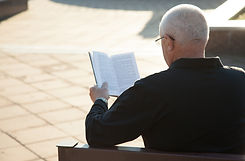 A Man Reading a Book Outdoors