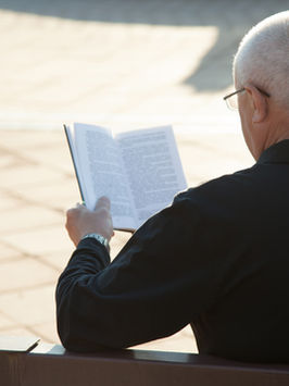 A Man Reading a Book Outdoors