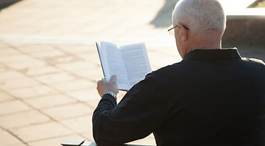 A Man Reading a Book Outdoors
