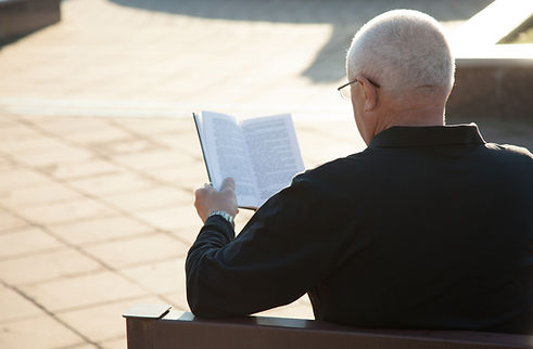 A Man Reading a Book Outdoors