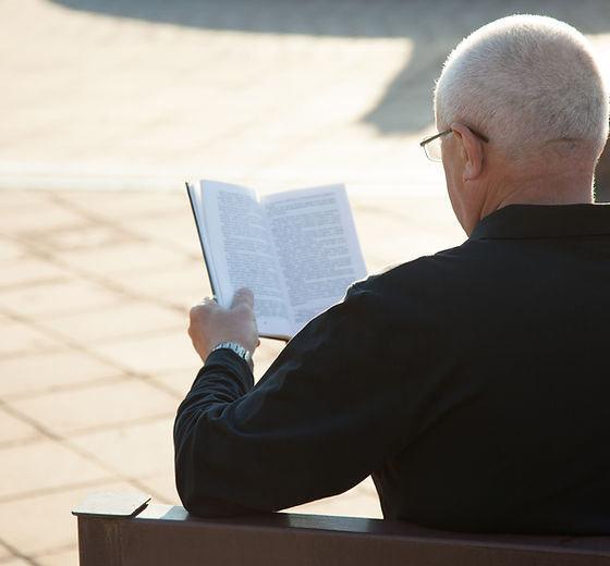 A Man Reading a Book Outdoors