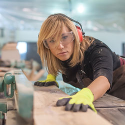 une femme menuisier qui travaille une planche de bois