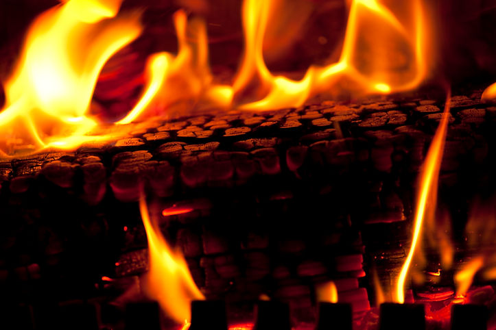 Hot coals and flames emitting from a hot burning fire