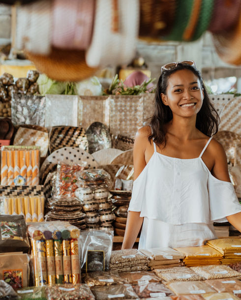 Una mujer de pie en una tienda de souvenirs.