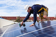Technician mounting rooftop solar panels