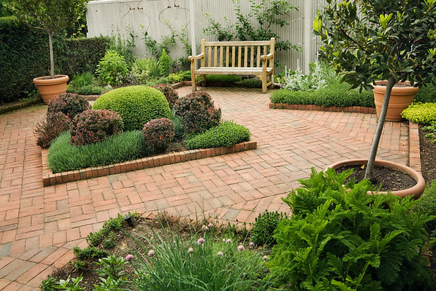 View of a professionally paved garden pathway with block borders and decorative shrubs