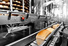 Industrial food production line with bread loaves moving on a conveyor belt, representing quality control and food safety processes.