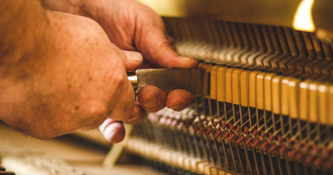 Instrument technician repairing a piano