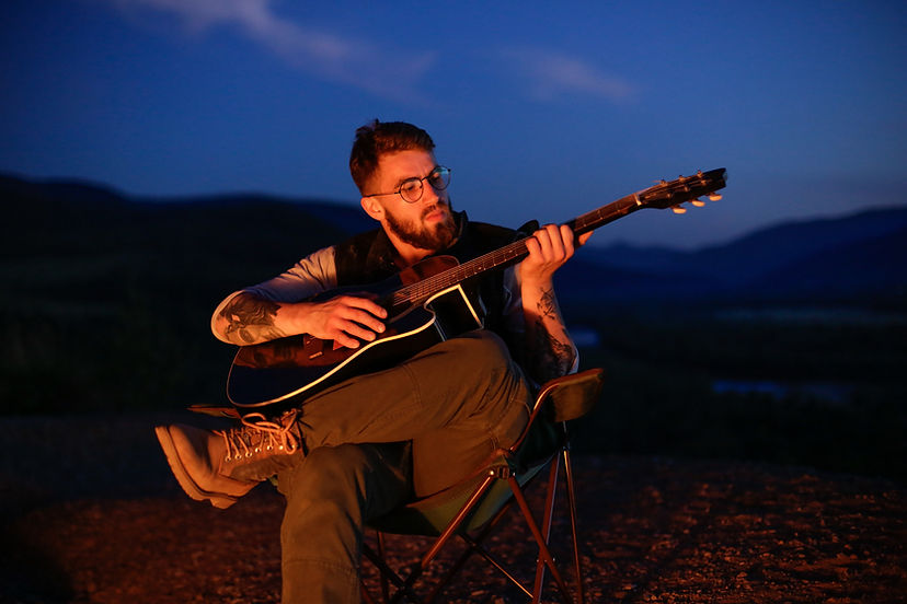 Playing guitar by a fire