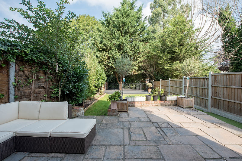 A general view of a back garden with patio and decking area