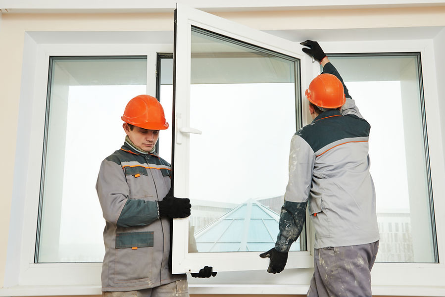 Two male industrial builders workers at window 