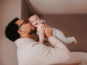 Father lovingly kissing his baby, symbolizing South Africa’s Constitutional Court ruling confirming equal parental leave rights for all parents.