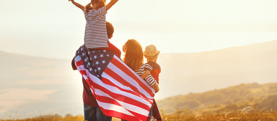 Rural family with an USA flag looking appreciating the sunset