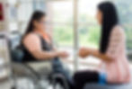 A woman and another woman on a wheelchair