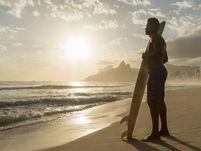 una playa con oleaje  lento y un hombre mirando hacia el horizonte