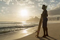 una playa con oleaje lento y un hombre mirando hacia el horizonte