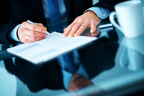 Cropped image of a businessman hands signing a contract or document at a desk