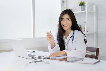 Smiling Doctor Sitting Behind Desk