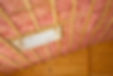 Fibreglass insulation installed in the sloping ceiling of a timber house