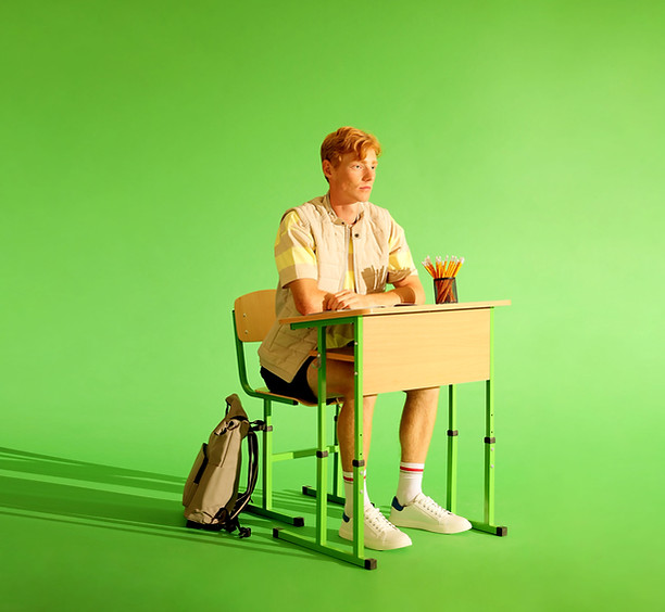 Student sitting at desk in empty room.