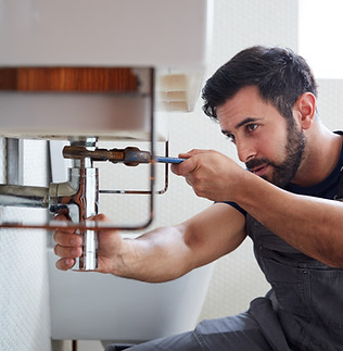 Plombier réparant une canalisation