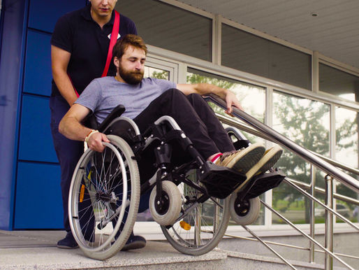 Helping a disabled friend on wheelchair down the stairs.