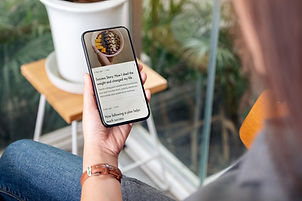Mujer joven leyendo un ebook de psicología en su celular, con estrategias prácticas para manejar ansiedad y estrés en su vida