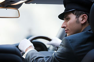 Chauffeur in suit and cap with white gloves focused