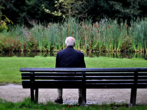 a man sitting on a bench in a park