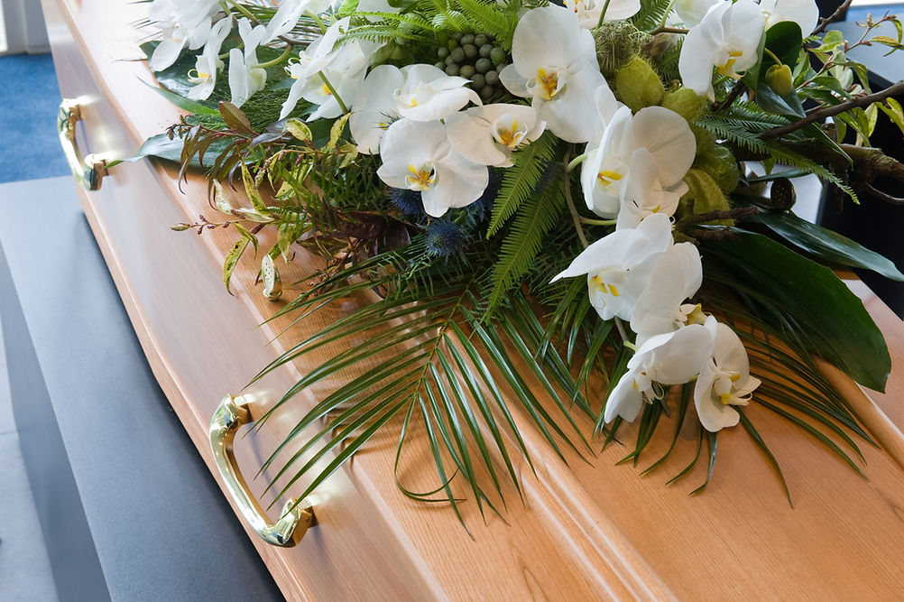 A coffin with a flower arrangement placed on it