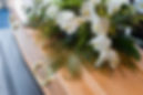 A coffin with a flower arrangement placed on it