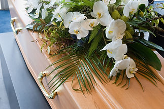 A coffin with a flower arrangement in a morgue