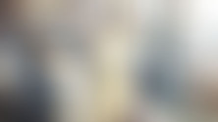 מתחם אופן ספייס עם עמדות מחשב ואנשים, חלק יושבים ליד עמדה וחלק עומדים ומדברים