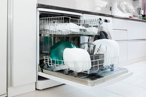 Open dishwasher with clean white plates, bowls, and utensils organized neatly in the lower rack