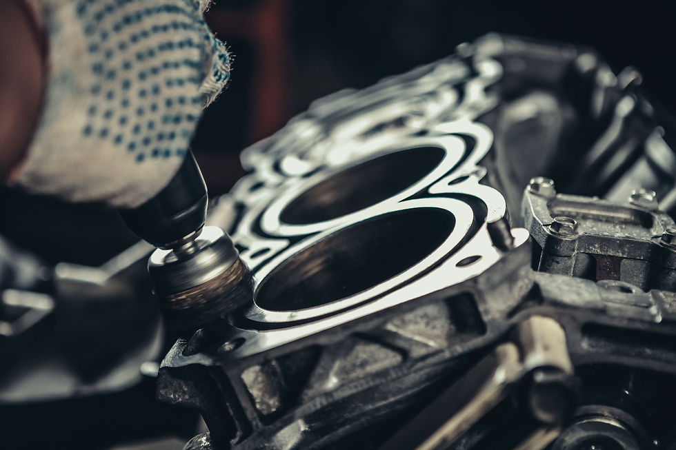 Mechanic using a power tool to clean a car engine block surface